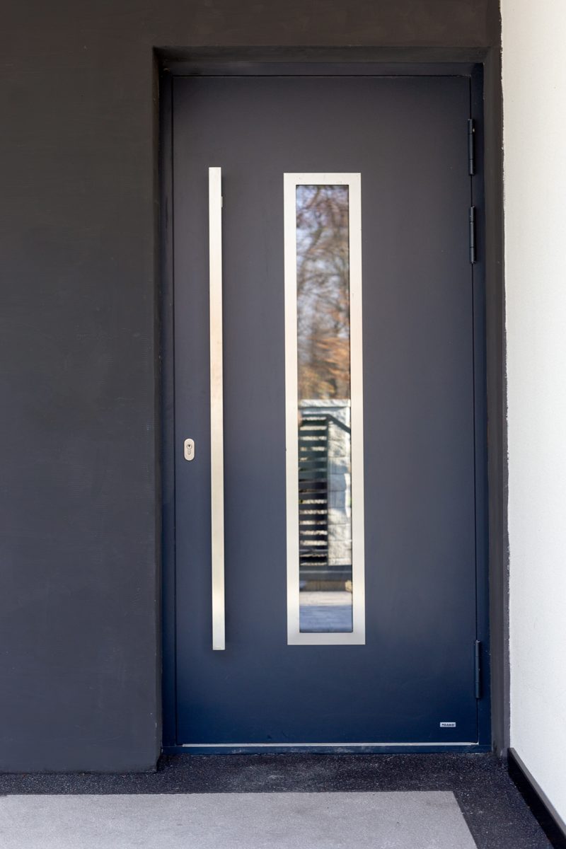 Dark grey front door with a tall glass strip and a long stainless steel handle