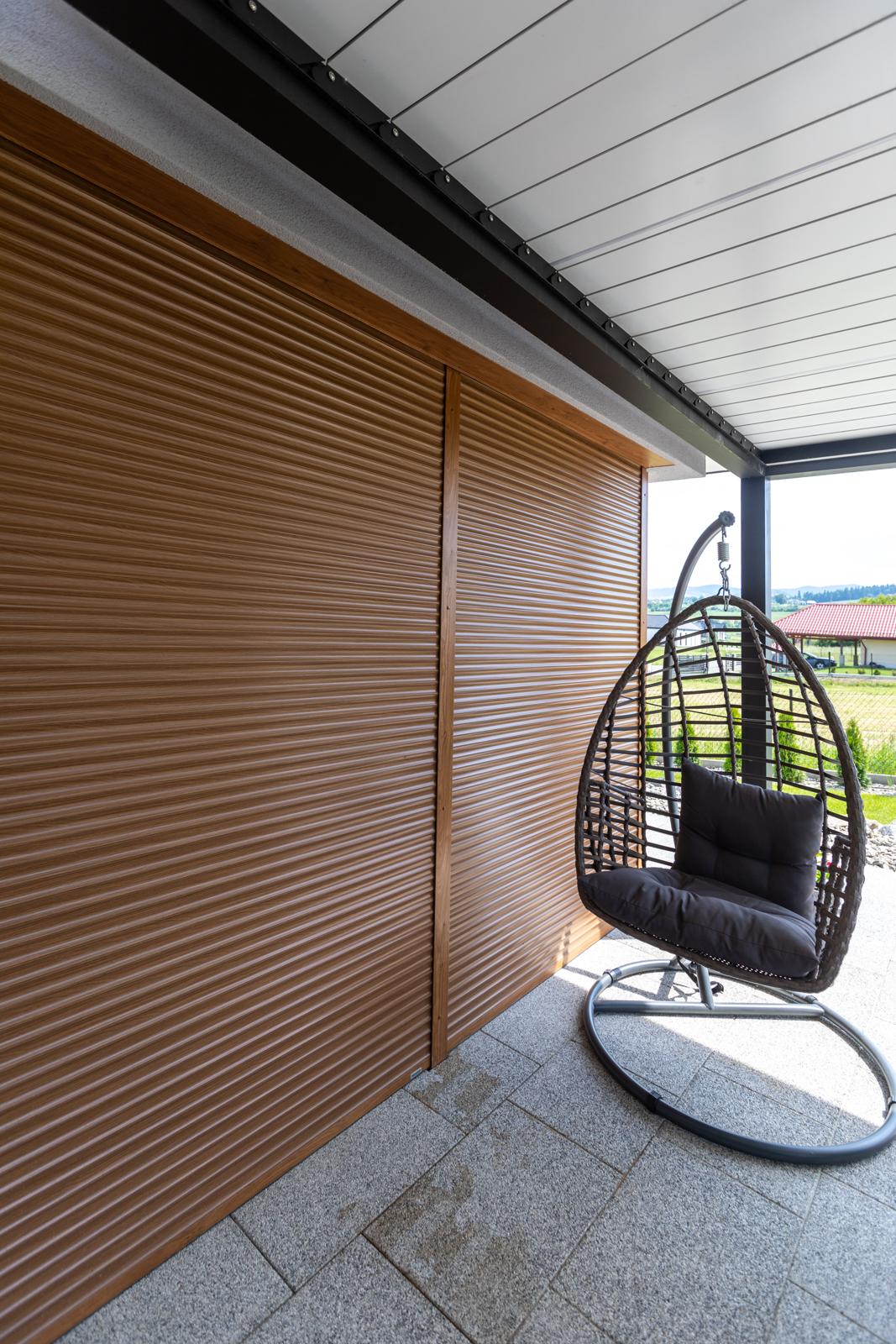 Wood-effect roller shutter closed over a covered terrace door